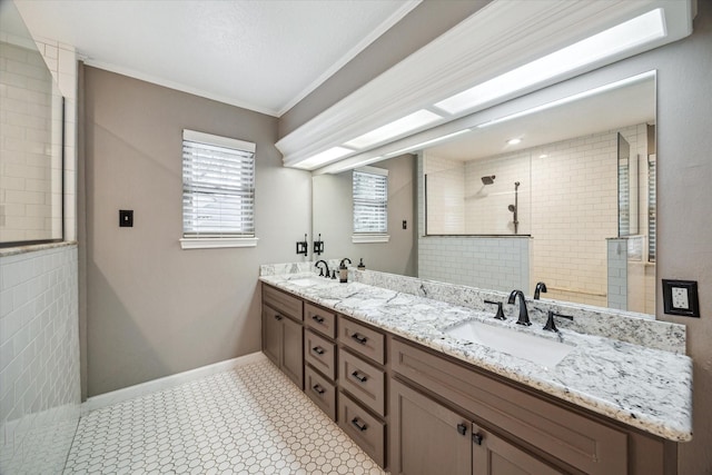 full bathroom featuring ornamental molding, tiled shower, a sink, and double vanity