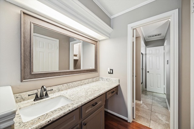 bathroom with ornamental molding, visible vents, vanity, and baseboards