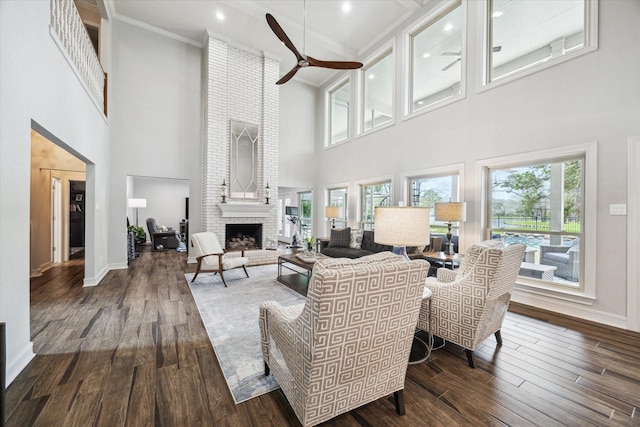 living room with baseboards, a fireplace, a ceiling fan, and hardwood / wood-style floors