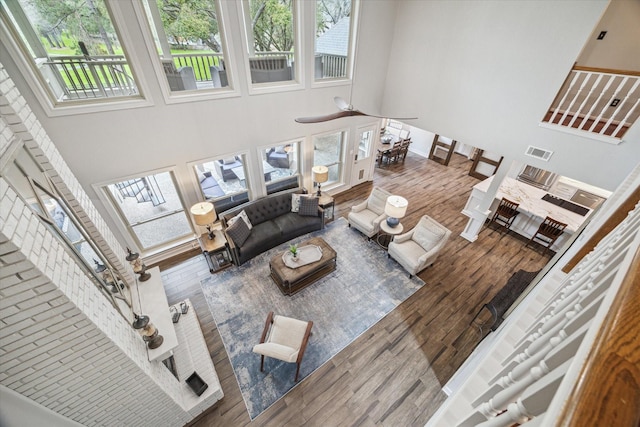 living area featuring a high ceiling, wood finished floors, and visible vents