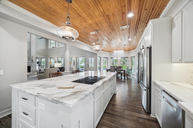 kitchen featuring a kitchen island, appliances with stainless steel finishes, dark wood-style flooring, crown molding, and a fireplace