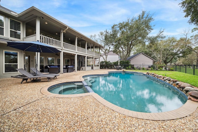 view of swimming pool with a lawn, a patio, ceiling fan, fence, and a pool with connected hot tub