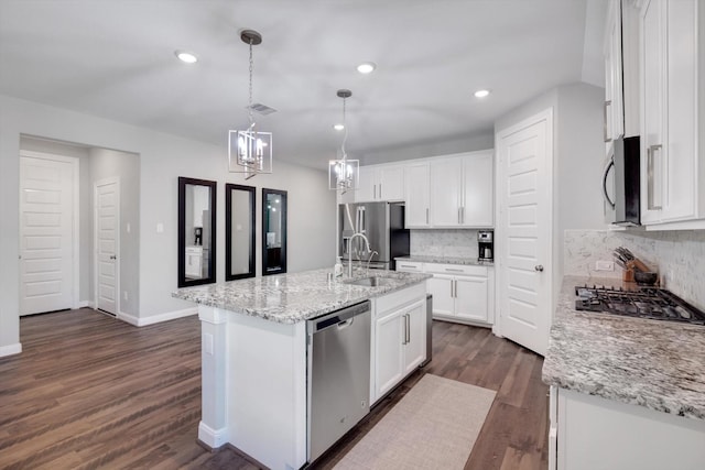 kitchen with a sink, dark wood finished floors, stainless steel appliances, white cabinetry, and a kitchen island with sink