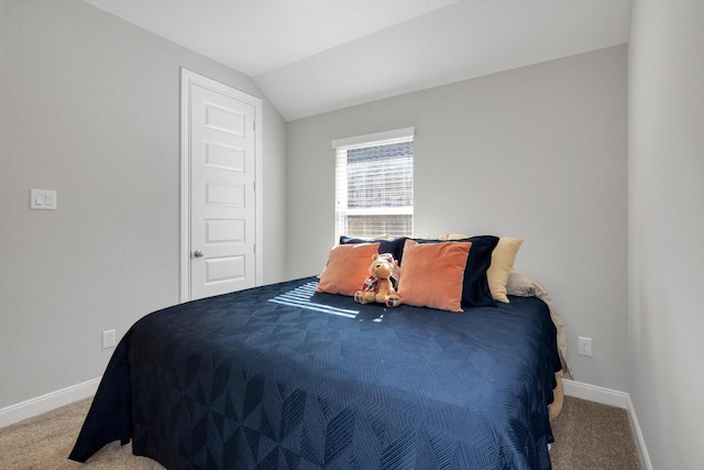 carpeted bedroom with baseboards and lofted ceiling