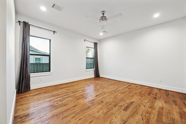 spare room with light wood-style floors, visible vents, and baseboards