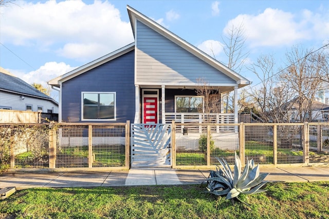 bungalow-style house featuring a porch, a fenced front yard, and a gate