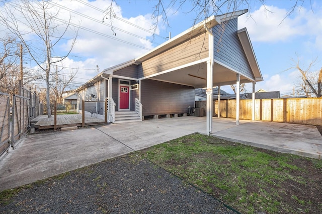 exterior space featuring driveway, fence, an attached carport, and entry steps