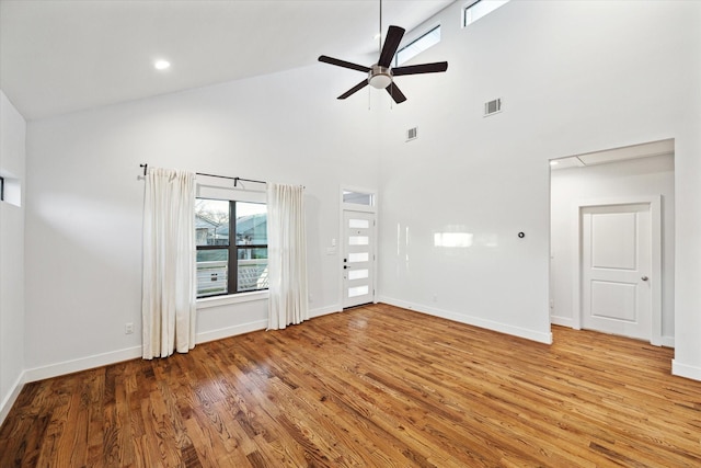 unfurnished living room with baseboards, ceiling fan, visible vents, and wood finished floors