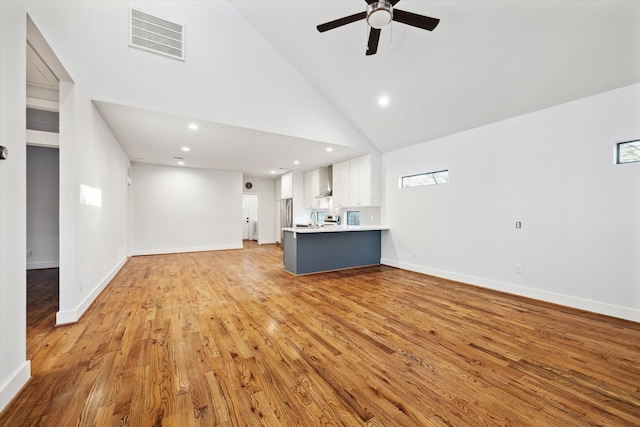 unfurnished living room featuring ceiling fan, high vaulted ceiling, visible vents, baseboards, and light wood-type flooring