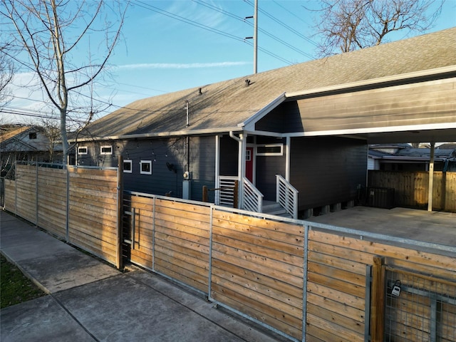 view of front of house featuring a shingled roof and fence