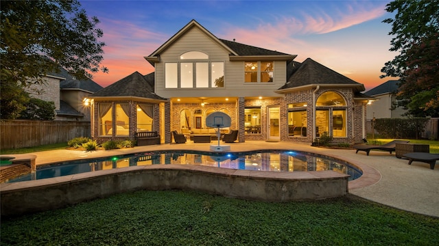 rear view of house with a patio area, fence, an outdoor hangout area, and brick siding