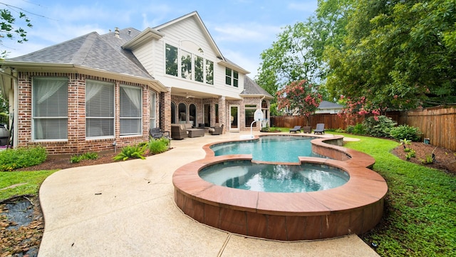 rear view of property with a patio area, a fenced backyard, a shingled roof, and brick siding