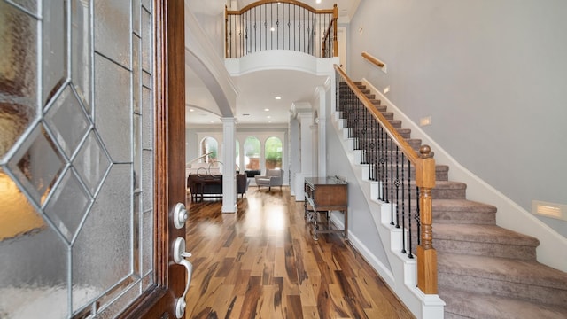 entrance foyer with recessed lighting, wood finished floors, baseboards, stairway, and ornate columns