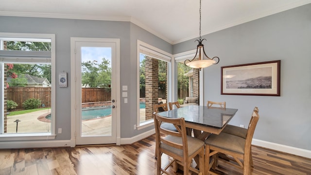 dining room with baseboards, ornamental molding, and wood finished floors