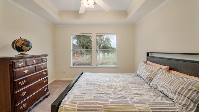 carpeted bedroom featuring ceiling fan, a tray ceiling, ornamental molding, and baseboards