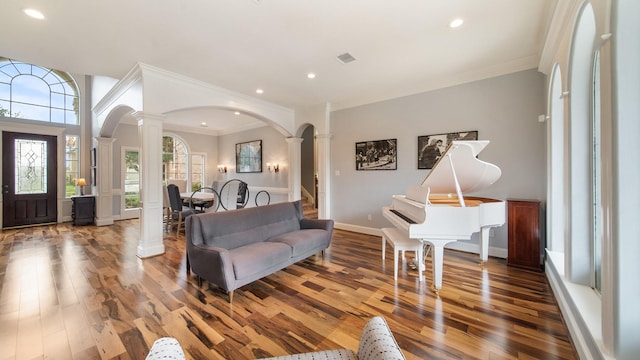 entrance foyer featuring decorative columns, arched walkways, wood finished floors, and recessed lighting