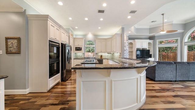 kitchen with tasteful backsplash, visible vents, open floor plan, dark stone counters, and black appliances