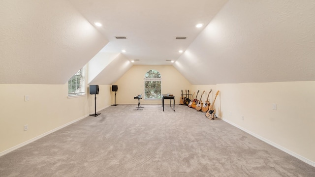 interior space with lofted ceiling, baseboards, visible vents, and a textured ceiling