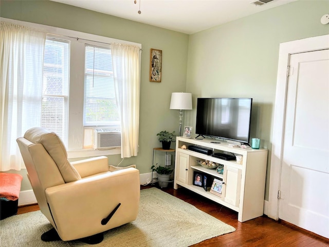 living area featuring dark wood finished floors, cooling unit, baseboards, and visible vents