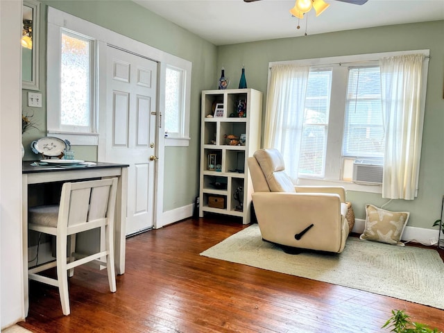 living area with cooling unit, wood-type flooring, baseboards, and a ceiling fan