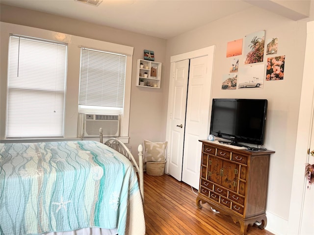 bedroom featuring a closet, visible vents, cooling unit, and wood finished floors