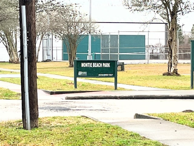 view of home's community with a lawn and fence