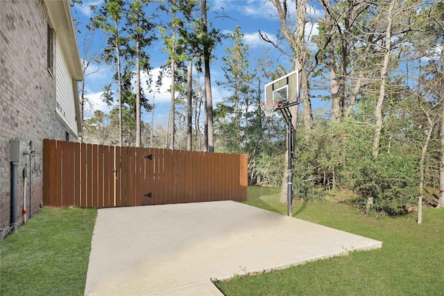 view of patio / terrace with basketball hoop and fence