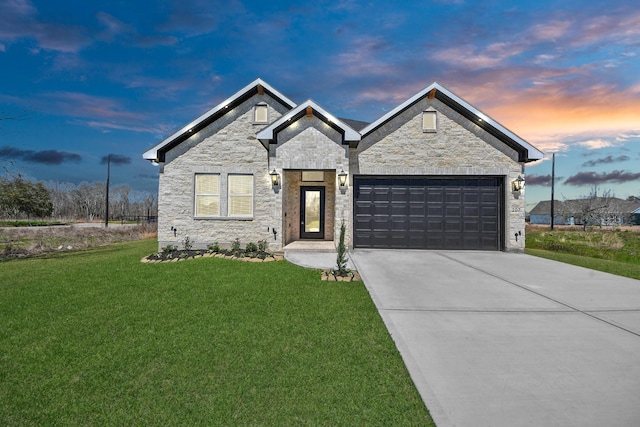 view of front of property featuring driveway, stone siding, a garage, and a front lawn