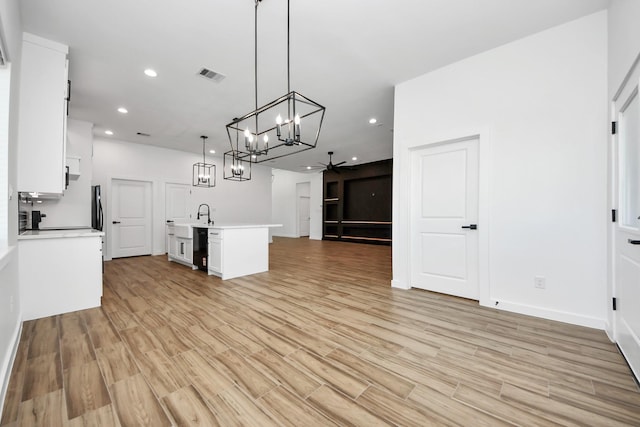 kitchen with visible vents, ceiling fan, light countertops, white cabinetry, and a sink