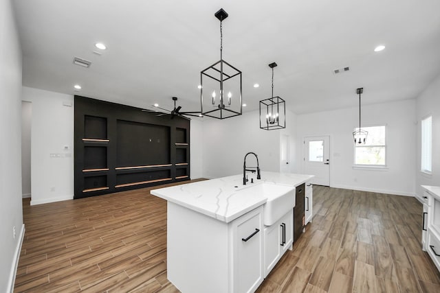 kitchen featuring light wood-type flooring, white cabinetry, a fireplace, and recessed lighting