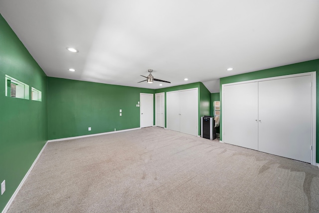 unfurnished bedroom with recessed lighting, two closets, and carpet flooring