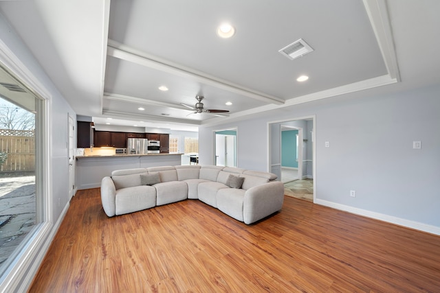 living room featuring light wood finished floors, recessed lighting, visible vents, beamed ceiling, and baseboards