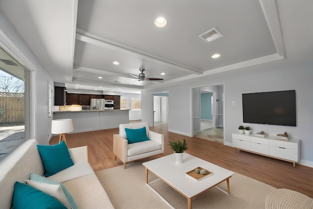 living area featuring light wood-style floors, baseboards, visible vents, and recessed lighting