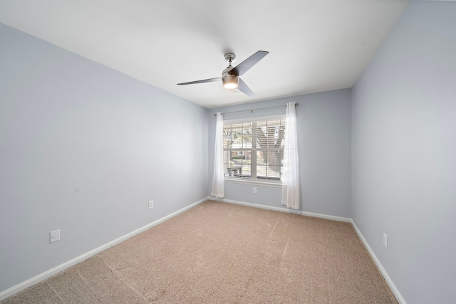 empty room featuring baseboards, a ceiling fan, and light colored carpet