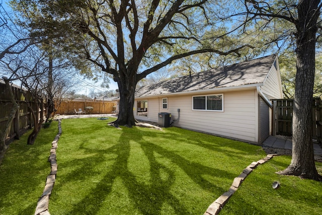 rear view of house featuring a yard, a patio area, a fenced backyard, and central air condition unit