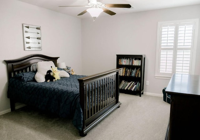 bedroom featuring a ceiling fan, light carpet, and baseboards