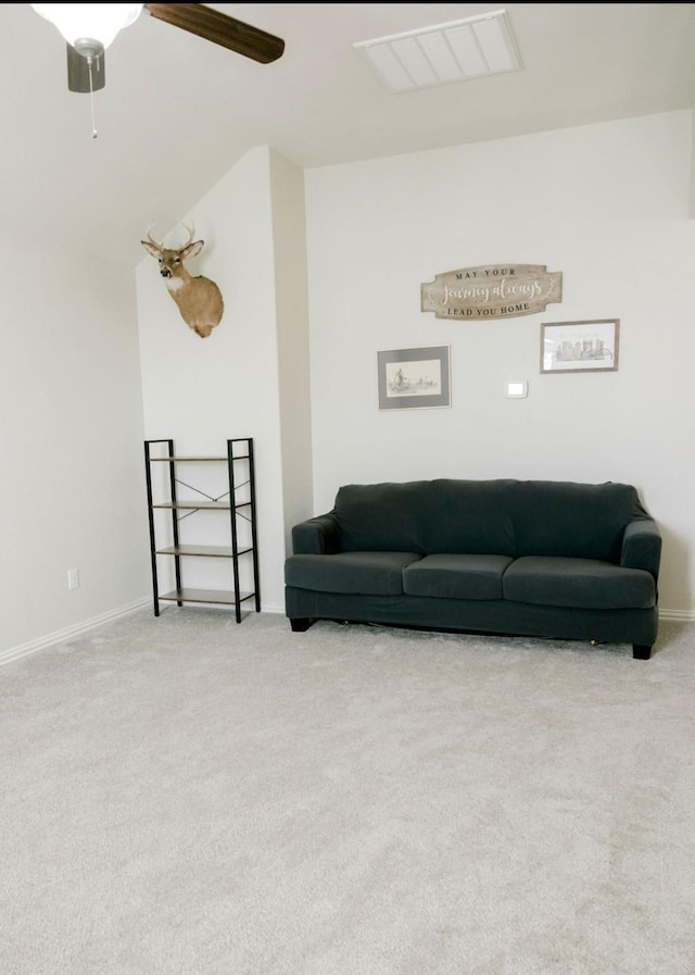 living room featuring carpet floors, visible vents, and a ceiling fan