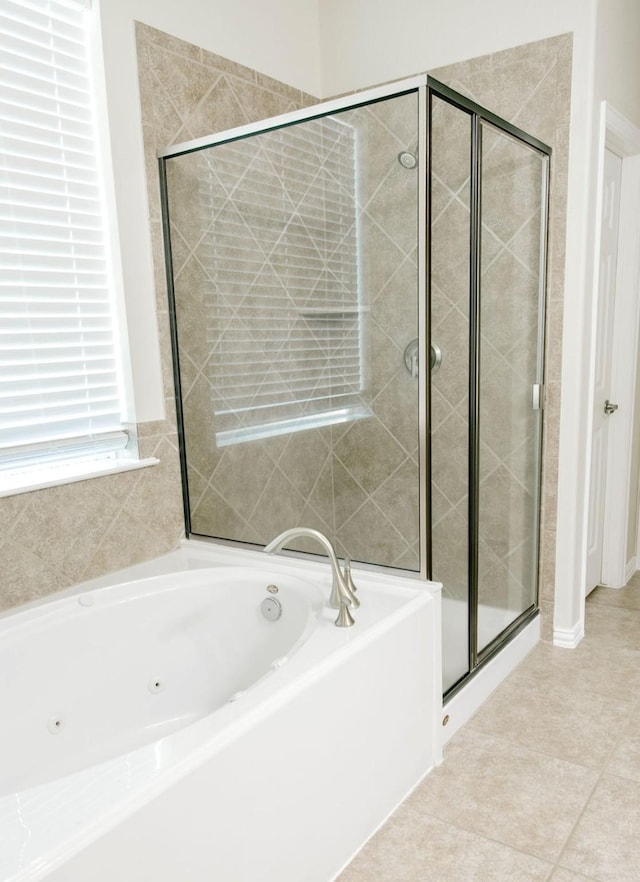 bathroom featuring a shower stall, a tub with jets, and tile patterned floors