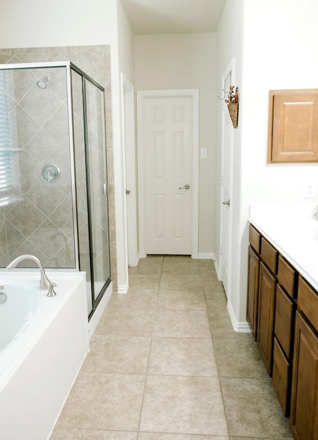 full bathroom with a garden tub, vanity, baseboards, a shower stall, and tile patterned floors