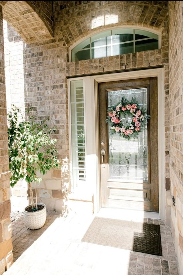 entrance to property featuring brick siding