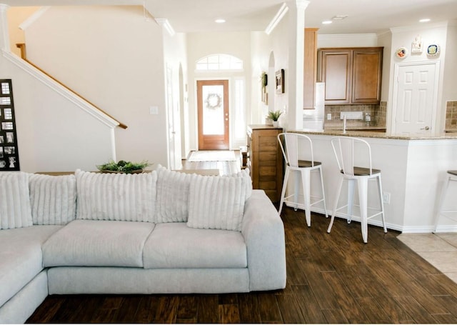 living area featuring crown molding, dark wood-style flooring, and recessed lighting