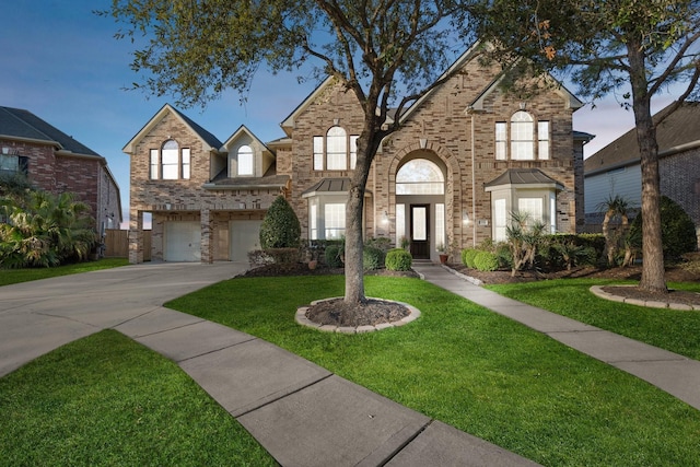 view of front of house featuring a front yard, brick siding, driveway, and an attached garage