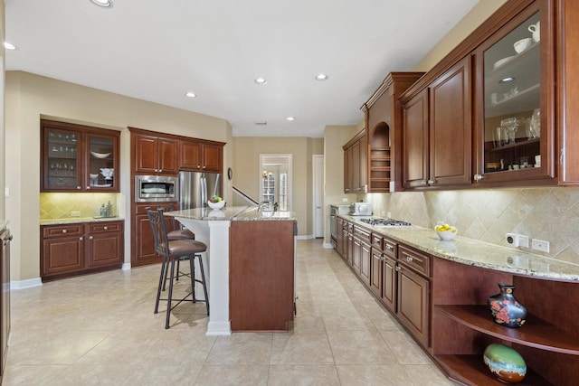 kitchen with a kitchen breakfast bar, open shelves, light stone counters, and stainless steel appliances