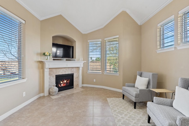 living area featuring crown molding, lofted ceiling, a premium fireplace, baseboards, and tile patterned floors