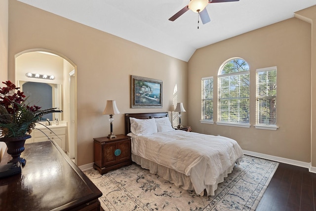 bedroom with vaulted ceiling, light wood-style flooring, baseboards, and ensuite bathroom