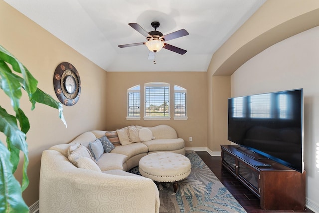 living room featuring lofted ceiling, a ceiling fan, baseboards, and dark wood-type flooring