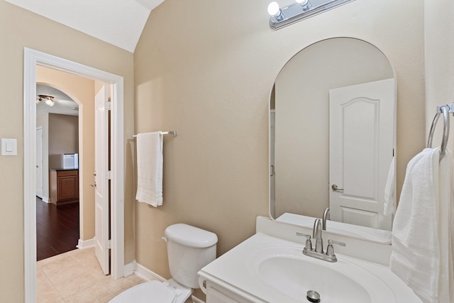 bathroom with toilet, tile patterned flooring, vanity, and baseboards