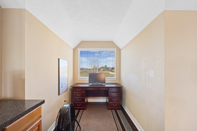 office area with lofted ceiling, dark colored carpet, a textured ceiling, and baseboards