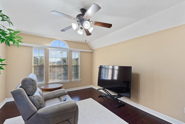 living room featuring vaulted ceiling, ceiling fan, dark wood finished floors, and baseboards