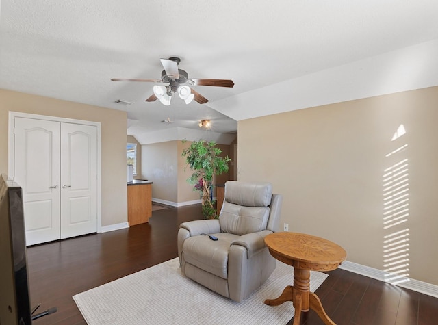 sitting room with vaulted ceiling, visible vents, dark wood finished floors, and baseboards